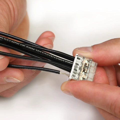 Hands using Push Wire Splicing Connector Wall Nuts For Solid And Stranded Conductors Eight Conductor With Light Gray Cover Tool Free Wiring