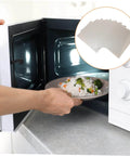 Person using microwave with 12 Pieces Mica Sheets For Microwave Oven Waveguide Cover Heat Resistant Fireproof Insulation Pads shown