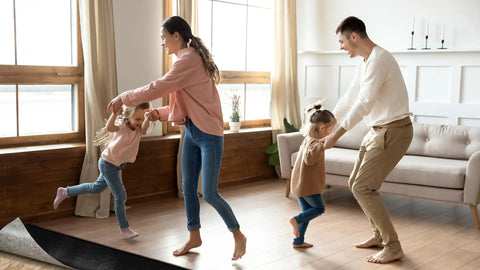 Family dancing on new flooring installed with 360 Sq Ft Flooring Underlayment For Luxury Vinyl Plank And Laminate.