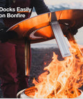 Person placing Bonfire Heat Deflector For Fire Pits, Boost Warmth And Comfort With A Wide Heat Radius over fire