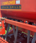 Two Pack Grain And Drill Seed Tube For Most Drills attached to red grain drill equipment in field, showing installation