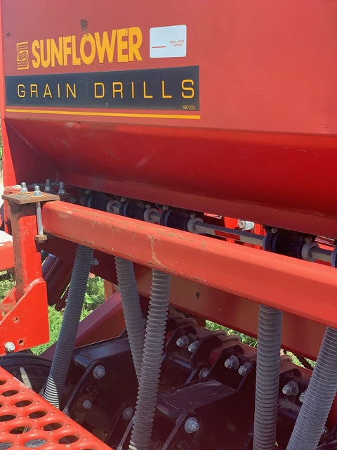 Two Pack Grain And Drill Seed Tube For Most Drills attached to red grain drill equipment in field, showing installation