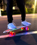 Person riding Kids Surfskate Board With Front Caster Trucks For Easy Turns And Big Pumping Power. Light-up wheels shown.