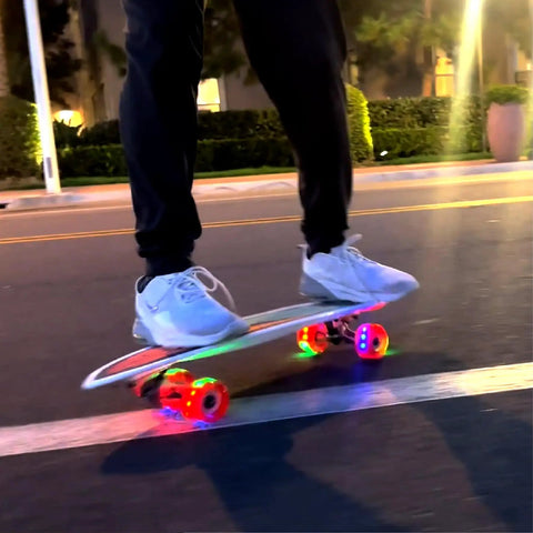 Person riding Kids Surfskate Board With Front Caster Trucks For Easy Turns And Big Pumping Power. Light-up wheels shown.