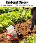 Manual Garden Seeder Hand Push Planter With 7 Nozzles in use on a farm row next to green crops, durable construction.