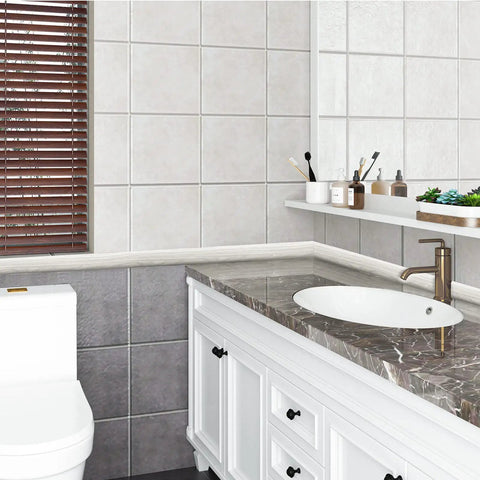 Bathroom with tiled walls, marble sink, brown blinds, and white storage cabinets under countertop with accessories