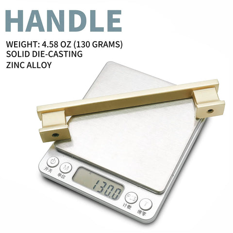 Brushed satin brass cabinet handle on scale, weight 4.58 oz, solid zinc alloy, 10 Pack 5 Inch Brushed Satin Brass Cabinet Handles For Dresser Drawers And Kitchen Cabinets With 5 Inch Hole Center Built From Solid Zinc Alloy For Rugged Durability And Corrosion Resistant Finish Perfect For Modern Furniture And Cabinets.