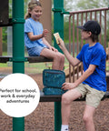 Kids at playground sharing snacks with Badass Pixel Camo Soft Sided Cooler Lunch Bag With Two Ice Packs And Six Hours Of Fridge Cold Chill For The Daily Grind Or Weekend Haul Insulated Carryall Keeping Your Eats Froze And Ready To Roll Anywhere.