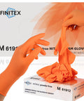 FINITEX orange nitrile disposable gloves being pulled from a box; size M, powder-free.