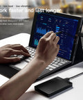 Person using 1TB Ultra Slim Portable External Hard Drive USB 3.0 with a tablet, showcasing plug and play feature.