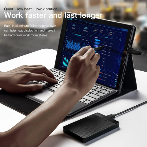 Person using 1TB Ultra Slim Portable External Hard Drive USB 3.0 with a tablet, showcasing plug and play feature.