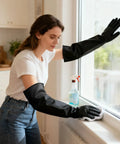 Woman using Heavy Duty Chemical Resistant Rubber Gloves With Killer Anti Slip Grip Long Cuff for cleaning window.