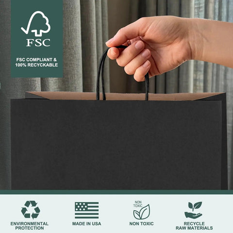 Hand holding 400 Pack Black Paper Gift Bags 16x6x12 Inches With Handles Made From Recycled Kraft Paper Eco Friendly Bulk Bags