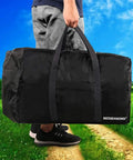 Person carrying Extra Large 96L Duffle Bag For Travel Lightweight And Foldable Gear Bag For Men And Women Black 80 By 26 By 46 Cm 60Lb Capacity