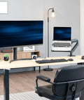 Built Tough Adjustable Laptop Desk Mount For 10 To 15.6 Inch Notebooks with laptop suspended above desk next to monitor.
