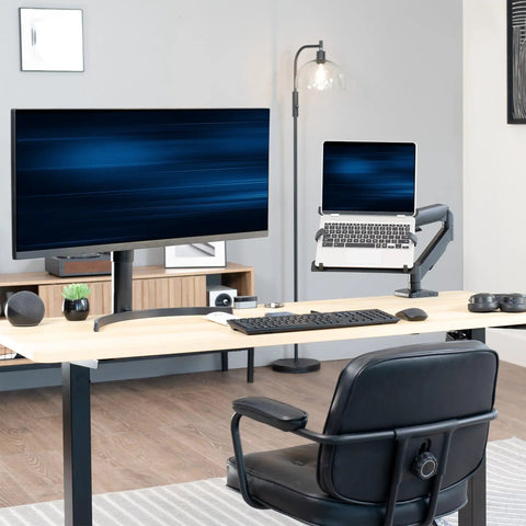 Built Tough Adjustable Laptop Desk Mount For 10 To 15.6 Inch Notebooks with laptop suspended above desk next to monitor.