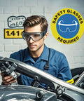 Worker wearing safety glasses under "Safety Glasses Required" sign in a workshop setting.