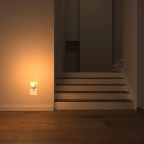 Easy Plug In Dusk To Dawn Night Light With 360 Degree Rotating LED illuminating a warm glow beside a staircase, UL Listed