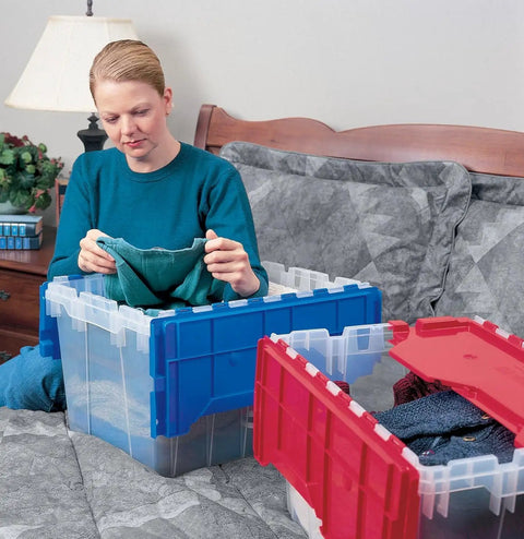Person organizing clothes in a KeepBox 12 Gallon Stackable Storage Tote With Attached Lid For Easy Nesting Clear Plastic Box