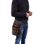 Person wearing Oil Tanned Leather Tool Pouch Bag For Carpenters And Handymen With 10 Pockets And 2 Hammer Holders 100 Percent Leather