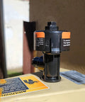 Front view of black plastic high-flow manual relief valve with orange warning labels mounted on a pool spa filter canister.