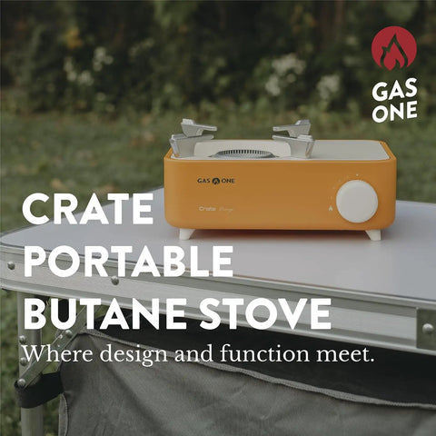 Butane Camp Stove For Hiking And Camping From The Crate Series on a table outdoors, orange, portable mini gas stove with spiral flame