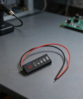 Straight Up Led Battery Voltage Gauge 5V To 21V with wires on table, showing battery levels on LED display.