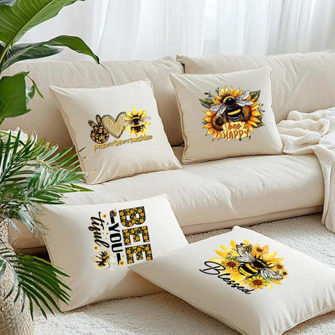 Decorative pillows with bee and sunflower iron-on transfers, featuring positive text designs and vibrant colors on a beige couch.