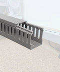 Grey PVC Wire Concealer Raceway Kit with Reverse Snap Cover for Cable Management, shown on a wood surface.