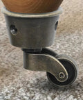 Close-up of Two Pack Vintage Zinc Alloy Swivel Caster Wheels with Antique Green Bronze Finish attached to furniture leg