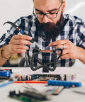 Man using Helping Hands Soldering Station With Flexible Y Shaped Arms And Non Slip Desk Clamp Base for PCB repair