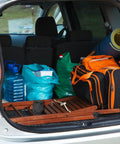 Car trunk with camping gear including a mat, water jugs, bags, and equipment, ready for use with an Ultralight Folding Camping Shovel Multitool for Outdoor Adventure High Carbon Steel Entrenching Tool With Digging Saw Bottle Opener And Pick Lightweight Portable Shovel for Hiking Backpacking Car Emergency Off Road.