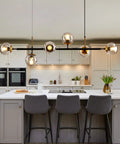 Mid-Century Glass Globe Pendant Light Fixture In Black And Gold, Semi-Flush Ceiling Chandelier in modern kitchen setting