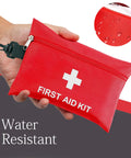 Red water-resistant travel first aid kit with white cross, zip pouch, and carabiner clip.