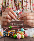 6 In 1 Jewelry Pliers Set For Beading And Wire Crafting 2 Piece Kit Bail Making Pliers in use with beads scattered on table.