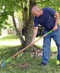 Person using 15 Inch Adjustable Self Cleaning Thatch Rake With Hardwood Handle For Lawn Care Curved Tines For Clearing Dead Grass Clippings