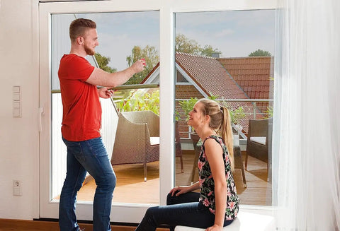 Couple installing Removable Static Cling Privacy And Decorative Glass Window Film For Home With UV Sun Protection No Glue No Residue