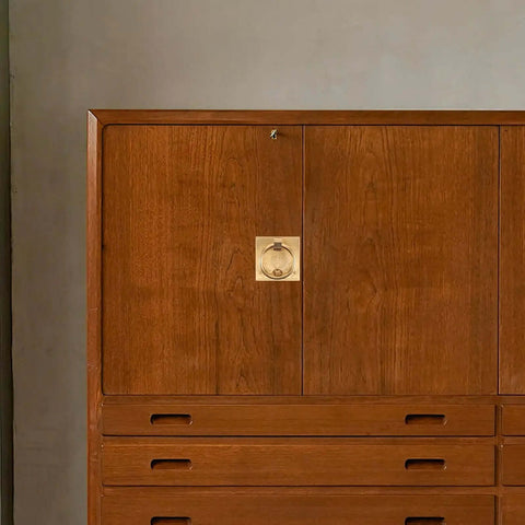 Wooden dresser with Vintage Brass Cabinet Pull Handle Set with Drop Ring Knobs in Chinese style on center cupboard door.