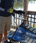 Man using Beast 180lb Ultra Strong Fishing Magnet Kit for river salvage with shopping cart