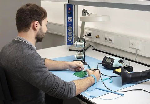 Person using ESD Soldering Mat Blue 600mm By 900mm Pro Grade Large Work Surface, showing anti-static and heat resistance features.