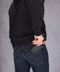 Person placing RFID Blocking Leather Wallet For Men With Removable ID Holder And Slim Design into back pocket