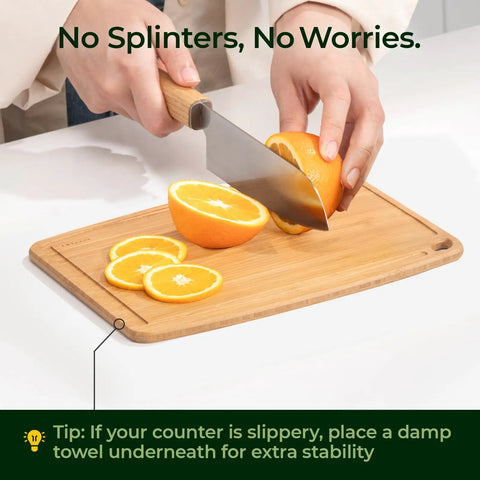 Person slicing oranges on Dishwasher Safe Carbonized Bamboo Cutting Board With Juice Groove For Fruit Veggies And Cheese