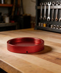 Rugged CNC Anodized Aluminum Telescope Dust Cover With Red Protective Cap for Camera Lenses on a workbench