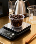 Waterproof Kitchen Scale With 0.1g Precision, 10kg/22lb Digital Food Scale in Stainless Steel with backlit display measuring coffee beans.