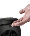 Hand feeling heat from Compact Ceramic Space Heater CD09250 With Adjustable Thermostat For Tabletop Or Under Desk Use.