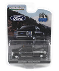 One Sixty Fourth Scale Diecast Ford F 450 Super Duty Dually With Wrecker Bed Black in packaging, agate black model truck displayed