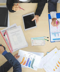Overhead view of a desk with charts, tablets, and Mesh Zipper Pouch Set Of 8 Colorful Waterproof Storage Bags for office use.
