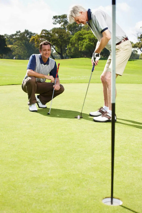 Two golfers using Wheel Like Golf Practice Ball With Adjustable Weight Putting Trainer And Instant Feedback To Improve Your Putting Stroke On The Green Build Confidence And Consistency on the green.