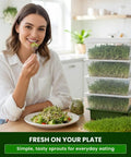 Woman eating sprouts with 4 Tier Sprouting Kit With Stackable Trays And Drain Spout For Home Sprouts on kitchen counter.