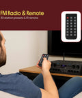 Man using remote to control 4 Channel Bluetooth Audio Amplifier For Home Stereo And Karaoke Use With 500W Peak Power.